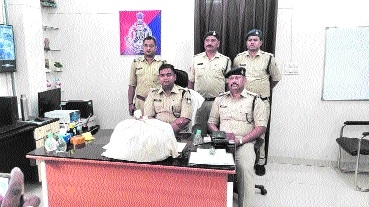 Police officers along with seized drugs