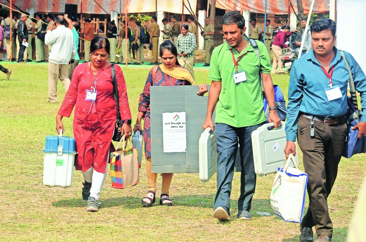 Polling officers carrying EVMs leaving for polling stations