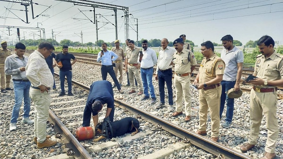 Railway officials remove a gas cylinder